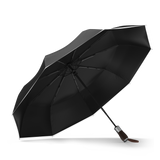 Black premium windproof compact umbrella, open and leaning left.