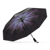 The Starry Night Top Best-Selling Windproof Compact Travel Umbrella is pictured on it's own, open and leaning to the left. The Canopy is black and the interior shows off the starry night motif.