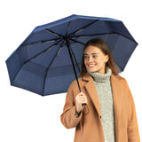 Woman holding Repel's best-selling windproof navy blue travel compact umbrella.