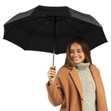 A woman holding the black travel compact umbrella that is windproof and best selling from Repel Umbrella